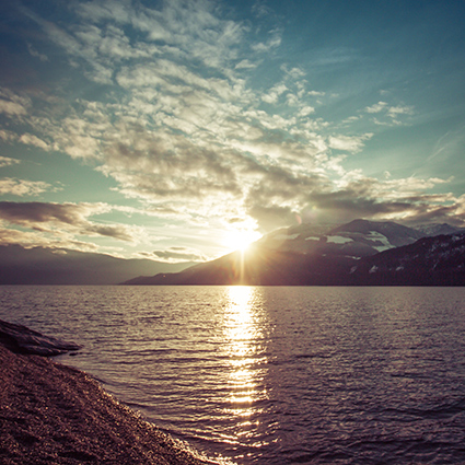 sunset over mountains with water kootenay lake